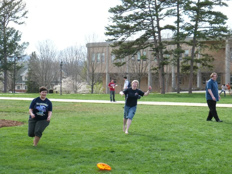 Computer Science Faculty Member at right in blue shirt in a frisbee game with his students.